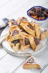 Traditional Jewish Hamantaschen cookies with  dried apricots, dates. Purim celebration concept. Сarnival holiday background. Selective focus. Copy space.