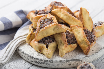 Traditional Jewish Hamantaschen cookies with  dried apricots, dates. Purim celebration concept. Сarnival holiday background. Selective focus. Copy space.