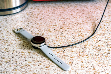 smart watch wireless charging on charging pad on kitchen worktop table