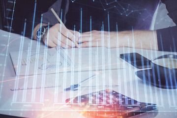 Double exposure of man doing analysis of stock market with forex graph.
