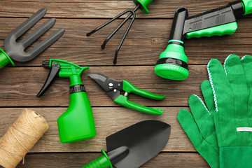 Gardening tools on grey wooden background, top view