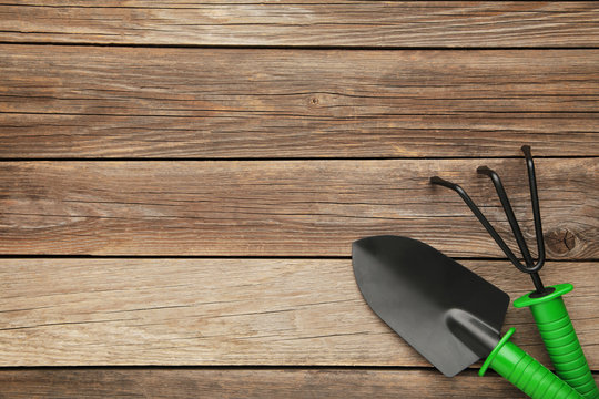 Gardening tools on grey wooden background, top view