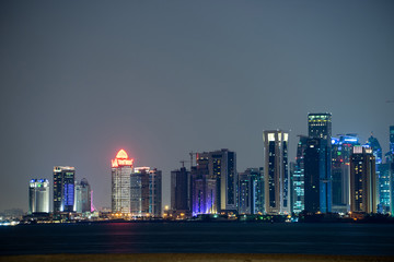 Vibrant Skyline of Doha at Night as seen from the opposite side of the capital city bay sunset