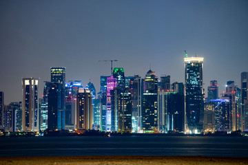 Vibrant Skyline of Doha at Night as seen from the opposite side of the capital city bay sunset