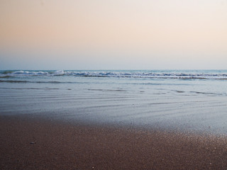 Obraz premium Empthy beach front. A view looking out through turquoise ocean and clear warm morning sky.