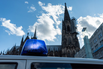 Fototapeta na wymiar Eingeschaltetes Blaulicht mit Kölner Dom im Hintergrund