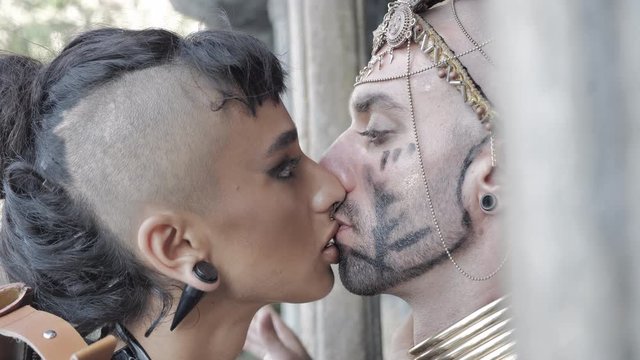 Adventure scene Girl in the style of a tomb raider kisses skull of an ethnic pagan shaman in an ancient temple