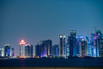 Fototapeta na wymiar Vibrant Skyline of Doha at Night as seen from the opposite side of the capital city bay sunset
