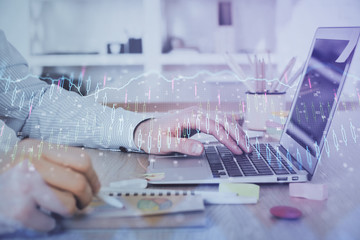 Multi exposure of stock market chart with man working on computer on background. Concept of financial analysis.
