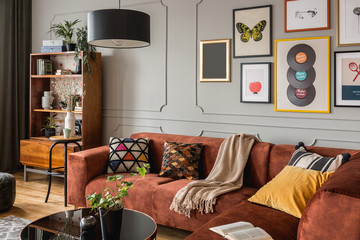 Gallery of trendy posters in elegant grey living room interior with brown corner sofa © Photographee.eu
