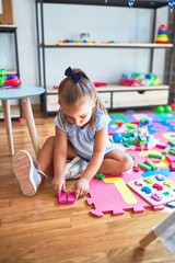 Young beautiful blonde girl kid enjoying play school with toys at kindergarten, smiling happy playing at home