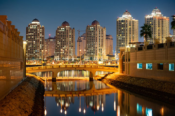 Fototapeta na wymiar The Pearl-Qatar area buildings with bridge and water in Doha, Qatar