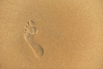 trace of a human bare foot on the yellow sand