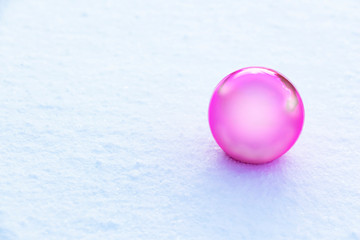 a ball of pale pink color on white snow
