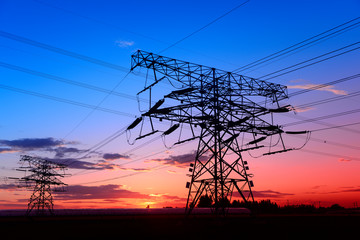 High voltage towers, silhouetted in the setting sun