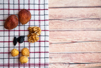 figs, raisins, apricots, nuts on a kitchen napkin on a wooden background