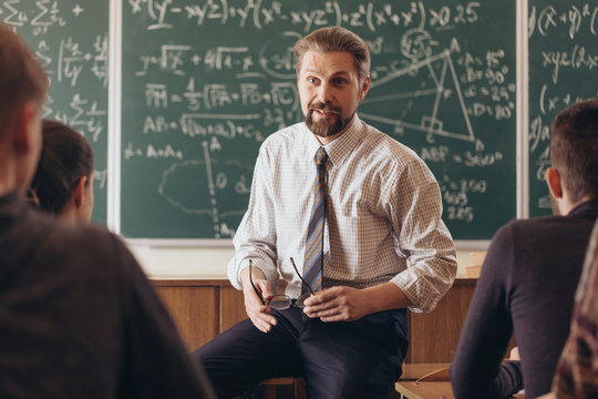 Cheerful bearded professor having a casual informal conversation with students during math seminar