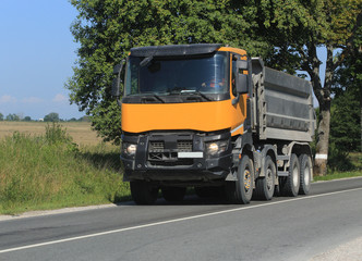 Fototapeta na wymiar dump truck carries cargo on road