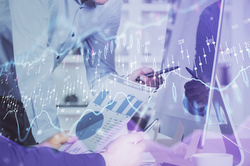 Double exposure of chart with businessman typing on computer in office on background. Concept of...