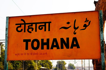 Tohana, Haryana, India - 19 November, 2019: 'TOHANA' written on a metal signboard in Hindi, English...