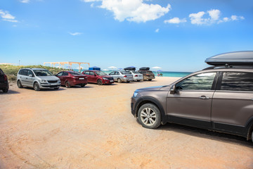 Fototapeta na wymiar Cars on a sandy beach by the sea