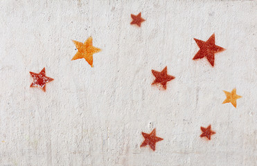 Stencil graffiti, red and yellow stars on a concrete wall - 327322739