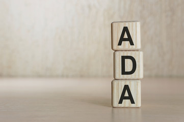 Word ADA on wooden cubes on light background