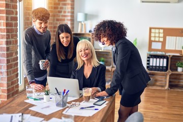Group of business workers smiling happy and confident. Working together with smile on face  using laptop at the office