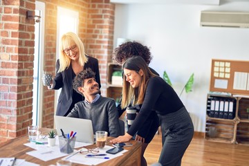 Group of business workers smiling happy and confident. Working together with smile on face  using laptop at the office