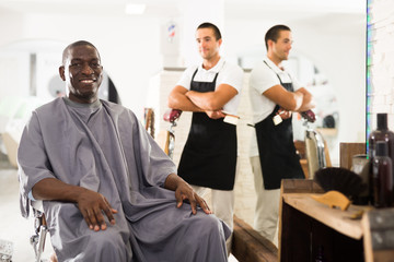 Fototapeta premium African man approving result of hairdresser work