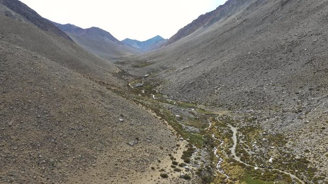An aerial view inside Andes mountains at Limari Valley, south Atacama. An amazing wild scenery. Arid idyllic valleys with green farm fields feed in by the river at the bottom of the valley
