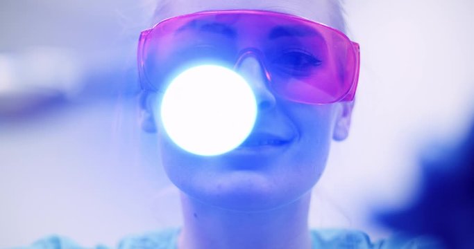 dentist using UV hardener during surgey at healthcare clinic