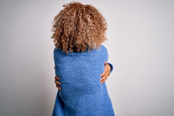 Young beautiful african american woman wearing turtleneck sweater over white background Hugging oneself happy and positive from backwards. Self love and self care