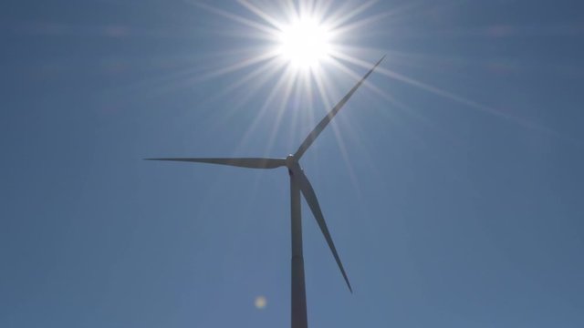 Wind turbine of renewable energy moving with sun in the sky a sunny day
