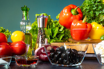 Preparation of Greek salad. Products for Greek salad. The recipe for a popular salad. Fresh vegetables, cheese, spices and olive oil. Mediterranean cuisine. Quick and healthy dish. Olives