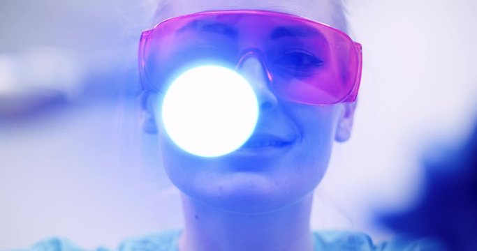 dentist using UV hardener during surgey at healthcare clinic
