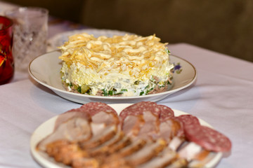 Plate with tuna salad and sliced pieces of sausage and brisket.