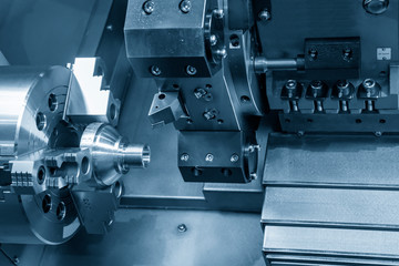 The CNC lathe machine in metal working process cutting thread the at the end of metal cone shape parts  in the light blue scene. The hi-technology metal working processing by CNC turning machine .