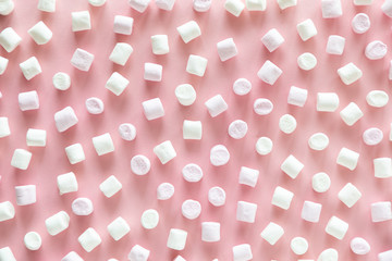 Background or texture of pink and white mini marshmallows on pink background