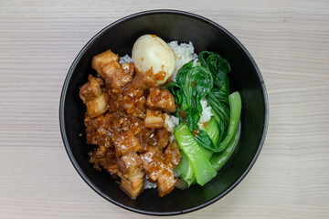 A bowl of lu rou fan, taiwanese braised pork belly with egg and bok choy.