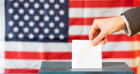usa elections  the hand of woman putting her vote in the ballot box