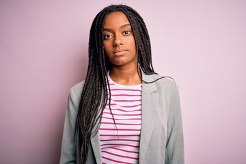 Young african american business woman standing over pink isolated background Relaxed with serious expression on face. Simple and natural looking at the camera.