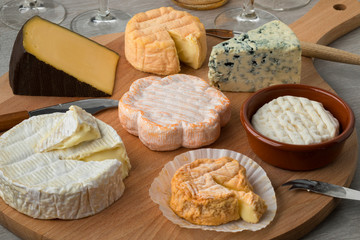 Wooden cheese board with a variety of cheeses