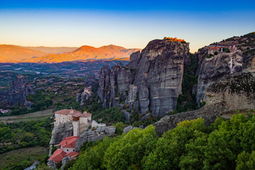 Fototapeta na wymiar Greece. Meteora at sunset. Monasteries on the rocks in Greece. World-famous sights of Greece. The mountainous landscape and monasteries on mountain tops. The stunning landscape of Meteora.