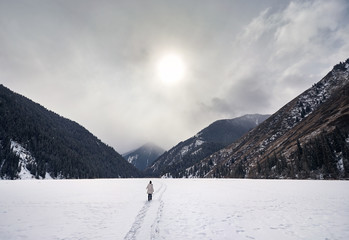 Tourist at frozen Kolsai Mountain Lake