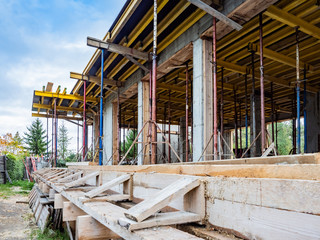 Fototapeta premium Construction site. Construction of a new cottage. Formwork of a new house. Construction work outside the city. Vacancies for builders. Implementation of the new house project.