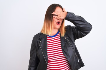 Young beautiful woman wearing striped shirt and jacket over isolated white background peeking in shock covering face and eyes with hand, looking through fingers with embarrassed expression.