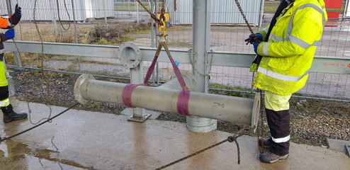 riggers moving pipe using two chain blocks 