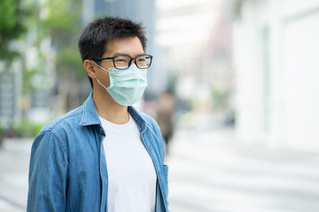 HandsomeMan wearing face mask protect filter against air pollution (PM2.5) or wear N95 mask. protect pollution, anti smog and viruses, Air pollution caused health problem. Global warming concept.