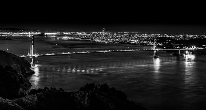 Fototapeta Black and white dark night panoramic view of Golden Gate Bridge and downtown city center in San Francisco, California, USA